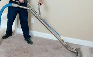 Professional operating a liquid removal machine on a carpeted floor in San Diego, CA